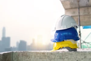 שלוש קסדות מגן מוערמות באתר בנייה על רקע קו רקיע